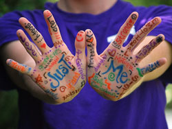 boy holding up hands with decorative writing